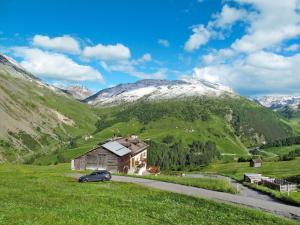 um carro estacionado em frente a uma casa numa montanha em Apartment Casa Crapena-2 by Interhome em Livigno