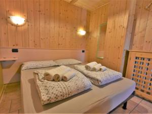 Duas camas num quarto com paredes de madeira em Apartment Casa Crapena-2 by Interhome em Livigno