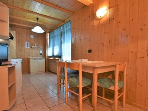 una cucina con pareti in legno, tavolo e sedie di Apartment Casa Crapena-2 by Interhome a Livigno