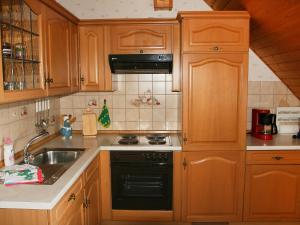 eine Küche mit Holzschränken und einem Herd mit Backofen in der Unterkunft Apartment Ferienhof Kuhberg-1 by Interhome in Kronach