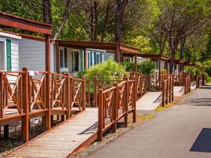 a wooden walkway next to a row of houses at Holiday Home Cecina Mare-11 by Interhome in Marina di Cecina