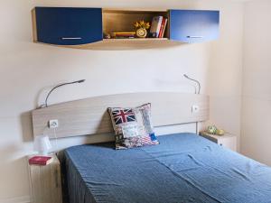a small bedroom with a bed with a blue bedspread at Holiday Home Cecina Mare-11 by Interhome in Marina di Cecina +13 photos