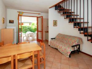 ein Wohnzimmer mit einem Esstisch und einer Treppe in der Unterkunft Holiday Home Mediterraneo-2 by Interhome in Rosolina Mare