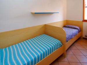 ロゾリーナ・マーレにあるHoliday Home Mediterraneo-2 by Interhomeのベッド2台(青と白のシーツ付)が備わる客室です。