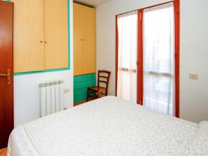 ein Schlafzimmer mit einem Bett und einem Fenster in der Unterkunft Holiday Home Mediterraneo-2 by Interhome in Rosolina Mare + 11 Fotos