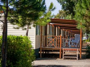 a cabin with two chairs and a deck at Holiday Home Cecina Mare-3 by Interhome in Marina di Cecina +13 photos