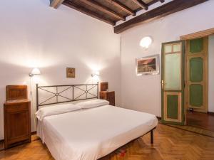 ローマにあるApartment Piazza Navona Charming by Interhomeのウッドフロアのベッドルーム1室(白いベッド1台付)