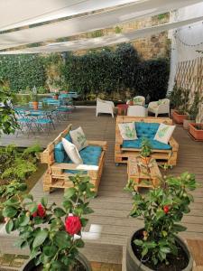 een patio met banken, tafels en bloemen bij Borgo Vergini Garden B&B in Napels