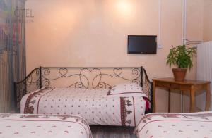 Postel nebo postele na pokoji v ubytování Hôtel Les Remparts