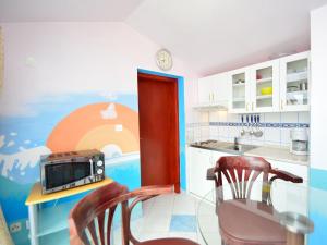 a kitchen with two chairs and a table with a microwave at Apartment Ivana-5 by Interhome in Raslina +12 photos