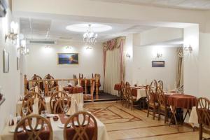 a dining room with tables and chairs and a chandelier at Бутик отель Печора in Moscow