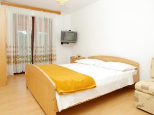Un dormitorio con una cama con una manta amarilla. en Apartment Šarenko-5 by Interhome, en Vela Luka