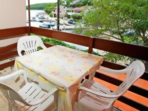 a table and chairs on a balcony with a view of a river at Apartment Šarenko-2 by Interhome in Vela Luka