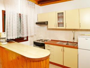 a small kitchen with white cabinets and a sink at Apartment Šarenko-2 by Interhome in Vela Luka +10 photos