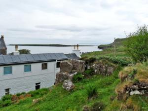 a house on a hill next to a body of water at Holiday Home Keepers by Interhome in Staffin