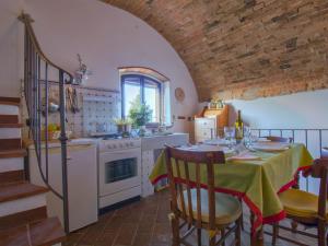 Una cocina con una mesa, una estufa y un fregadero. en Holiday Home Torre di Meo by Interhome, en Castelnuovo D'elsa