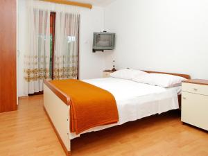 a bedroom with a bed and a tv on a wall at Apartment Šarenko-4 by Interhome in Vela Luka