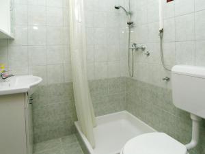 a bathroom with a shower and a toilet and a sink at Apartment Šarenko-4 by Interhome in Vela Luka +3 photos