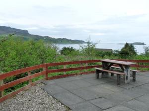 a wooden bench sitting next to a fence at Holiday Home Ewan's by Interhome in Staffin