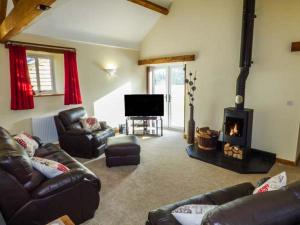 a living room with a couch and a fireplace at Ty Buddug in Llandegla