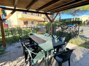 a table and chairs sitting under a pergola at Apartment Riviera 9 by Interhome in Marina di Cecina