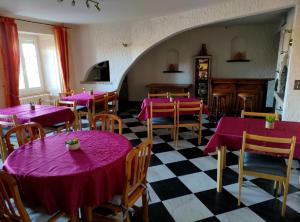 een restaurant met paarse tafels en stoelen en een geruite vloer bij Hôtel Les Remparts in Nozeroy