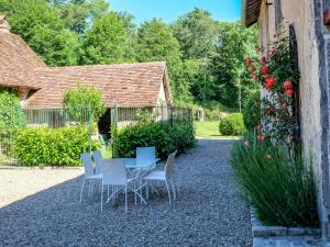 a patio with a table and chairs in front of a house at Holiday Home La Maison du Chateau by Interhome in La Tagnière