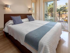 a large bed with blue pillows in a bedroom at Apartment Marmara by Interhome in Jávea