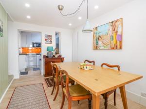 a kitchen and dining room with a wooden table and chairs at Kits Cottage in Hythe