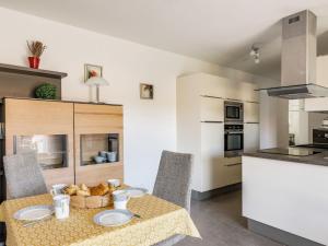 Una cocina y un comedor con mesa y sillas. en Apartment Résidence Cap Marine by Interhome, en Drammont