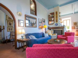 a living room with a blue couch and pink chairs at Villa Tamerici by Interhome in Villa Boretti