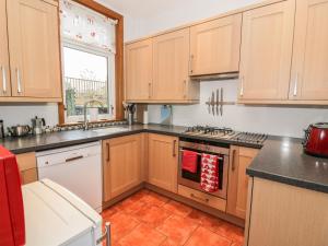 a kitchen with wooden cabinets and a stove top oven at 63 Rosetta Road in Peebles