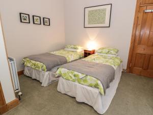two beds in a small room with a door at 63 Rosetta Road in Peebles