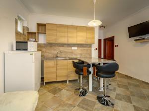 a kitchen with a counter and two bar stools at Holiday Home Zsuzsi by Interhome in Balatonszemes