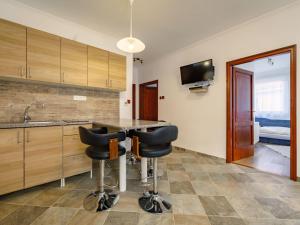 a kitchen with a counter and two bar stools at Holiday Home Zsuzsi by Interhome in Balatonszemes