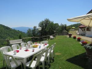 Biały stół z białymi krzesłami na trawniku w obiekcie Holiday Home Podere Le Ripe by Interhome w mieście Santa Maria a Vezzano