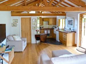 een woonkamer en een keuken met een witte bank en een tafel bij The Springs in Ryde
