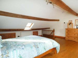 ein Schlafzimmer mit einem Bett und einer Holzkommode in der Unterkunft Garreg Wen Isaf Bach in Pen-y-groes