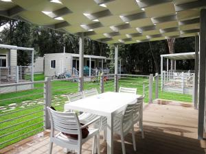 巴亞多米吉亞的住宿－Holiday Home Maxi Caravan Capri by Interhome，木制甲板上的白色桌子和椅子
