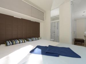 Säng eller sängar i ett rum på Holiday Home Maxi Caravan Capri by Interhome
