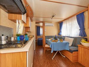 バイア・ドミツィアにあるHoliday Home Maxi Caravan Escale by Interhomeのキッチン、リビングルーム(キャラバン内のテーブル付)
