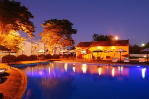 a swimming pool in front of a building at night at Hotel Vale Da Telha in Aljezur