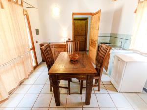 eine Küche mit einem Holztisch und Stühlen sowie einem Kühlschrank in der Unterkunft Holiday Home Mare di Ginepri - BAD115 by Interhome in Badesi