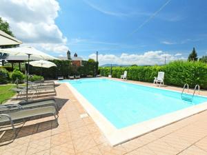 a large swimming pool with chairs and umbrellas at Apartment Villastrada-2 by Interhome in Villastrada