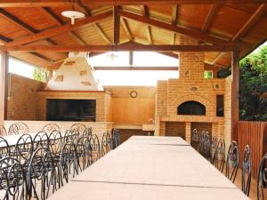 a long table and chairs in front of a brick oven at Apartment Villastrada-2 by Interhome in Villastrada