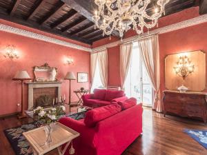 ローマにあるApartment Spanish Steps Top Location by Interhomeの赤い家具とシャンデリアが備わるリビングルーム