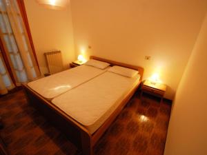 リニャーノ・サッビアドーロにあるApartment Ofelia by Interhomeのベッドルーム1室(ベッド1台、2つのテーブルに照明付)