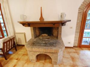 リニャーノ・サッビアドーロにあるApartment Ofelia by Interhomeの煉瓦造りの暖炉のあるリビングルーム(犬が寝ている)