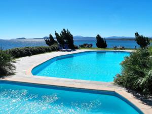 una grande piscina blu con l'oceano sullo sfondo di Apartment Castagno by Interhome a Casa Tamponi