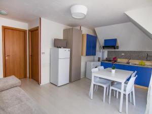 una pequeña cocina con mesa blanca y sillas en Apartment Cala Luna-3 by Interhome, en Porto dʼAscoli